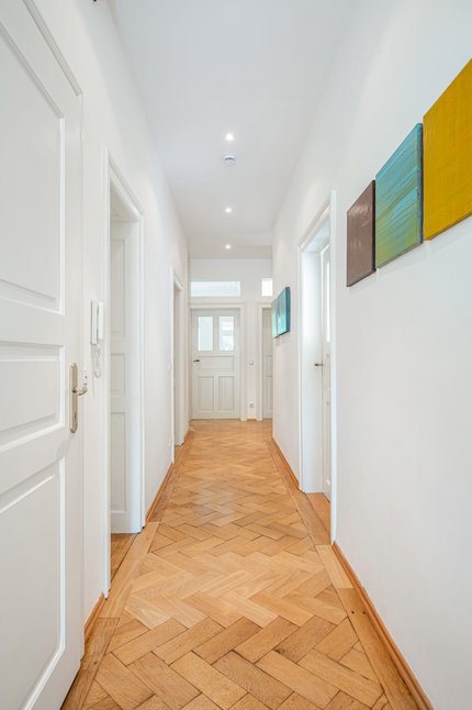 Herringbone parquet flooring and enchanting stucco details convey historical flair