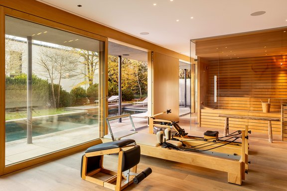 Second living room by the pool, serving as a fitness area with a sauna and fireplace