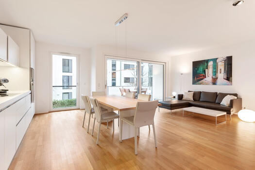 Open-concept living/dining/kitchen area with access to the west-facing balcony