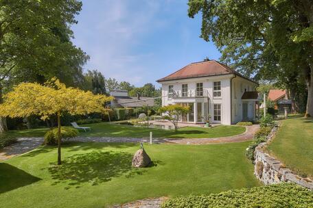 A timelessly elegant villa with a natural swimming pond and a magnificent park-style garden in Ammerland
