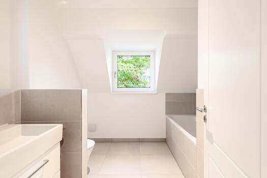 Bathroom with natural light, featuring a bath and shower