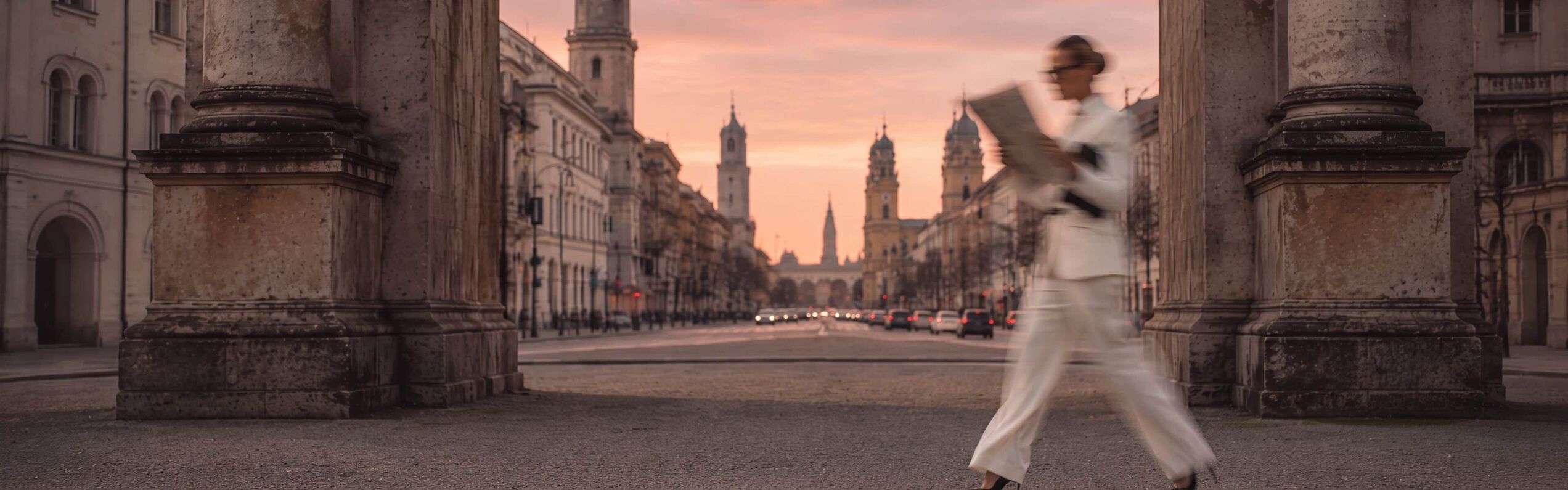 Frau liest Zeitung während Gehen am Siegestor München